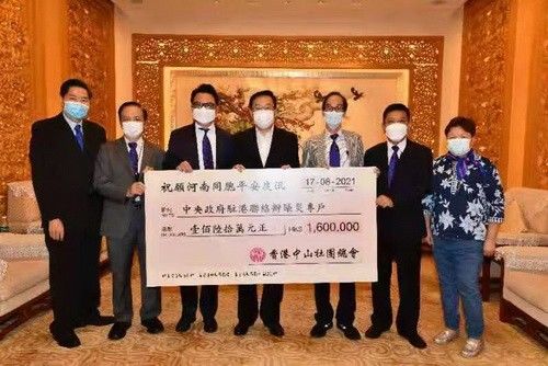 中联办副主任何靖（中）从中山市荣誉市民、香港中山社团总会主席杨凯山（左3）手中接过160万港币支票，